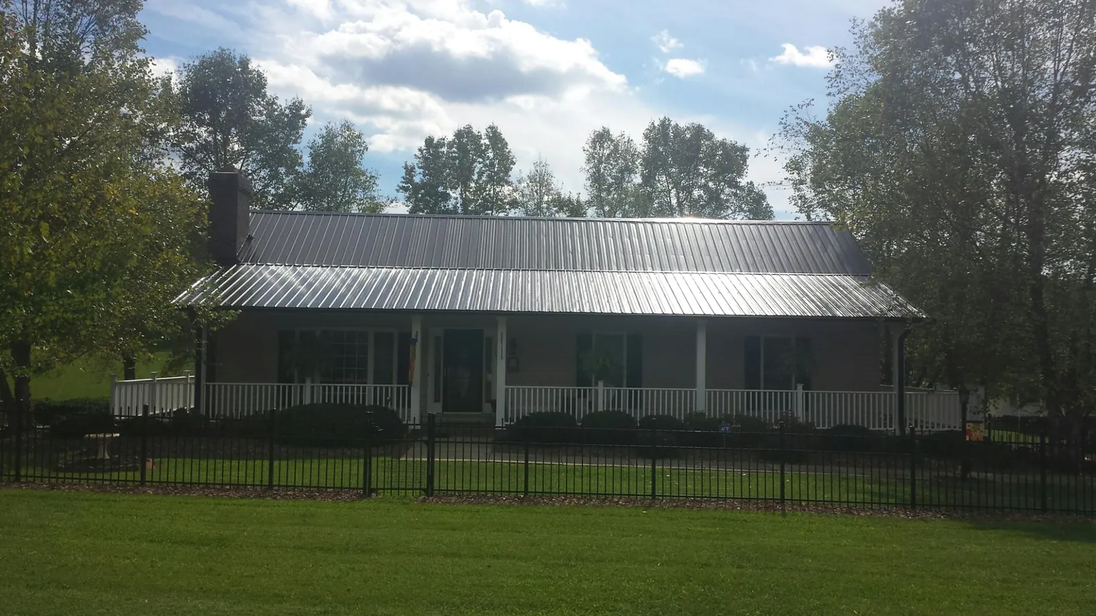 Gray metal roof on a brick ranch with a full width front porch — Gutter Guard Installation work by our crew in Cincinnati
